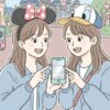 東京ディズニーリゾートでスマートフォンを見ながらプリクラの場所を探す2人の日本人女性。